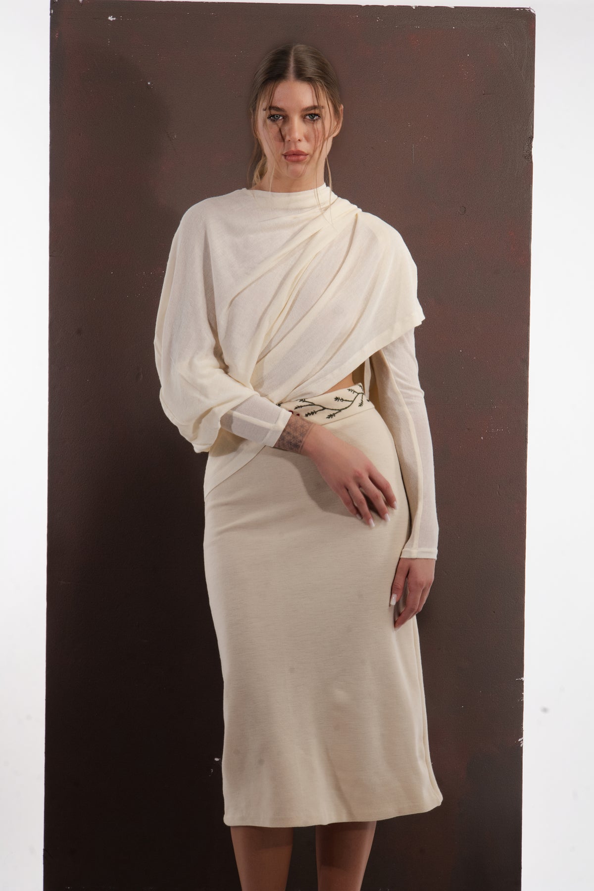 ALISADUDAJ ivory wool draped top and midi skirt set, three-quarter view with hand at the hip