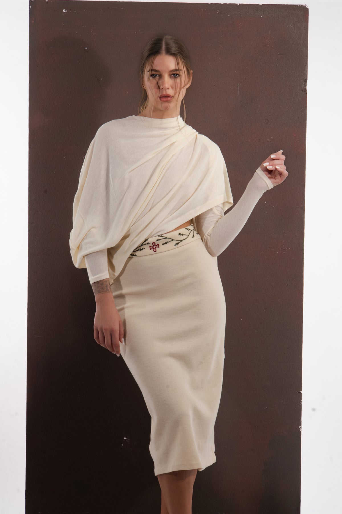ALISADUDAJ ivory wool draped top and embroidered midi skirt, front view with arm raised showing sleeve drape