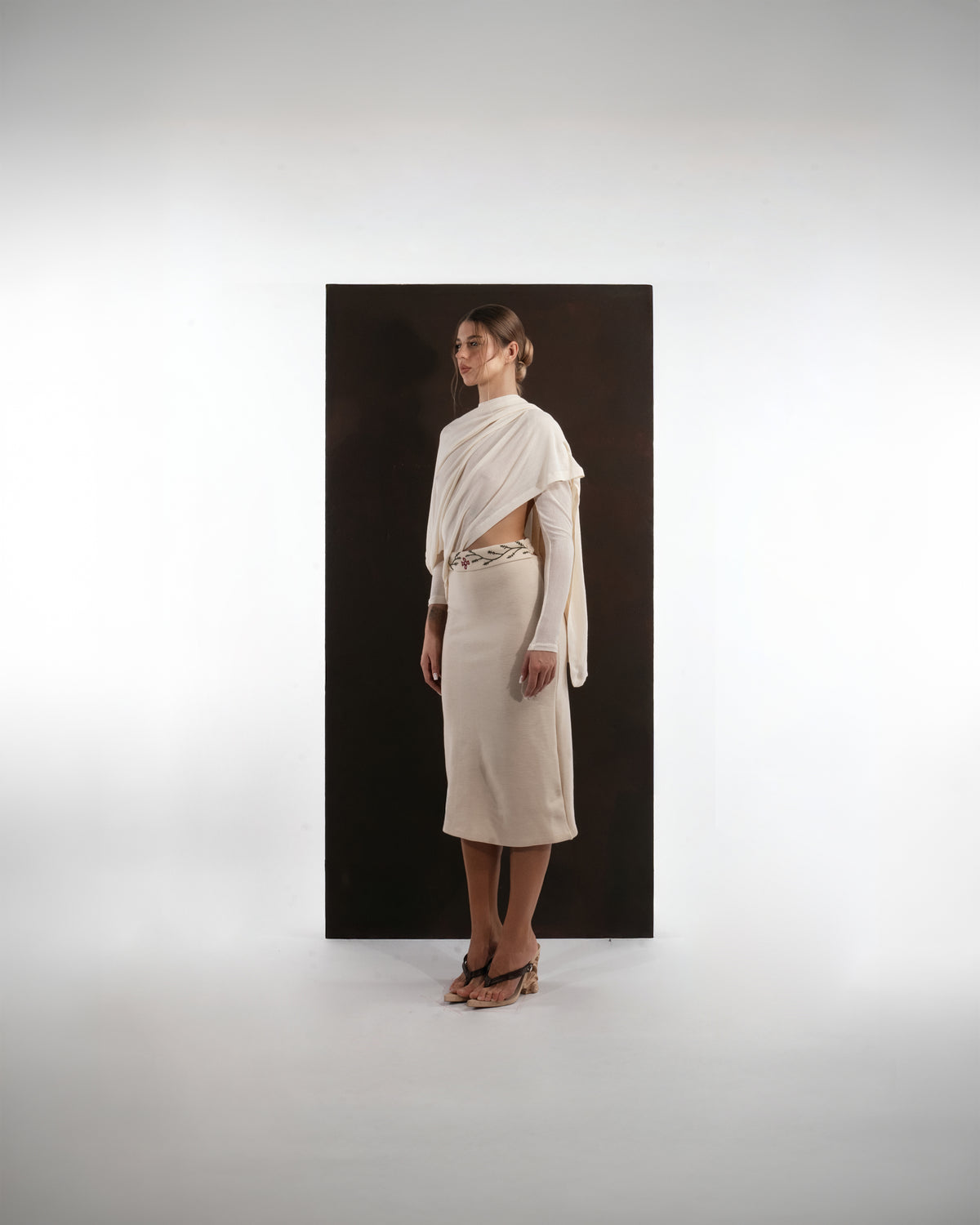 ALISADUDAJ ivory wool draped top and midi skirt set, side three-quarter view showing waist cut-out and drape