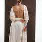 ALISADUDAJ ivory wool open-back drape dress, back view with hands behind the waist showing hem points