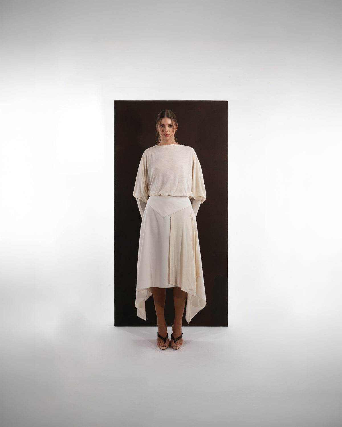 ALISADUDAJ ivory wool open-back drape dress, front view showing batwing sleeves and pointed skirt panels