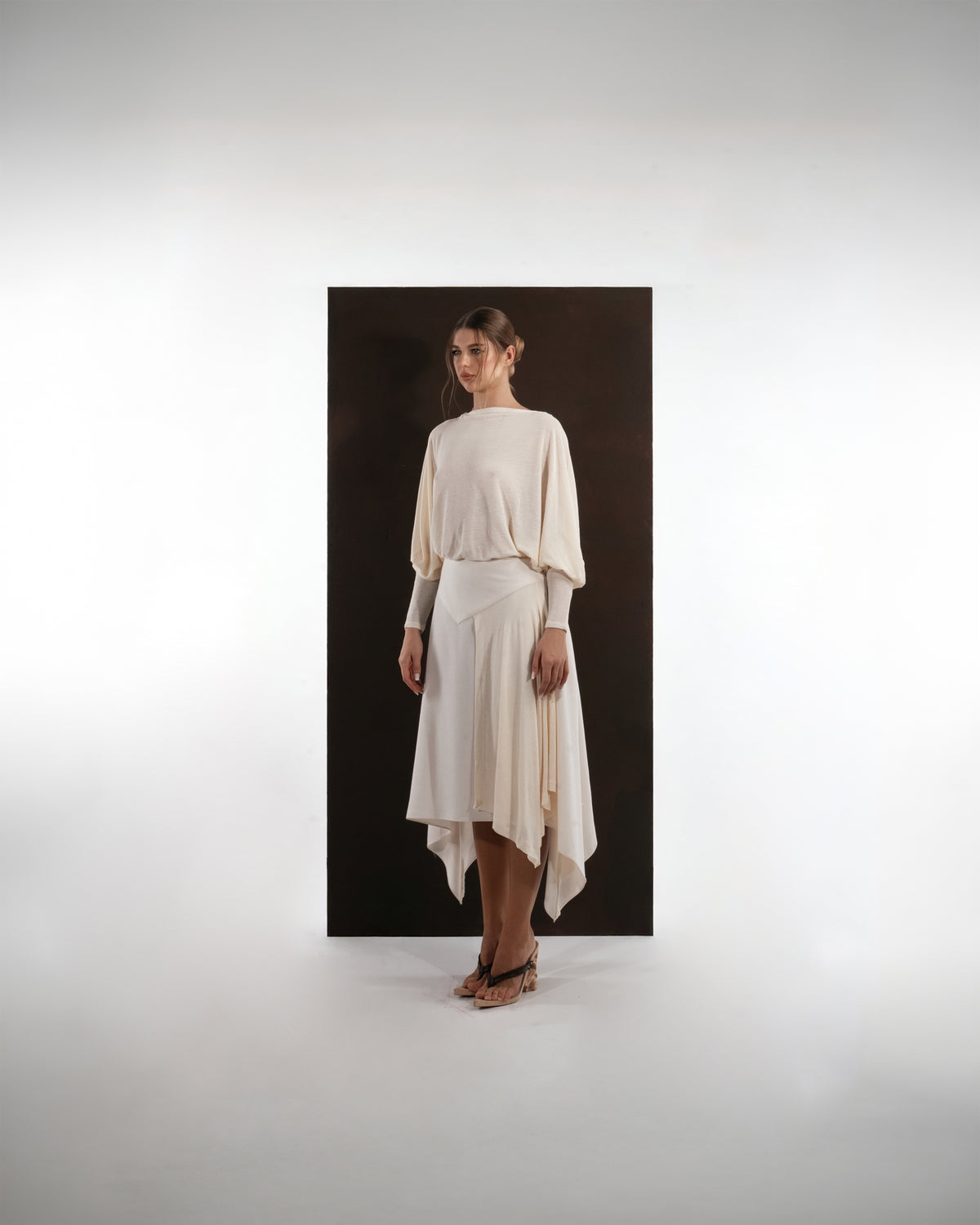 ALISADUDAJ ivory wool open-back drape dress, front three-quarter view showing pointed waist yoke