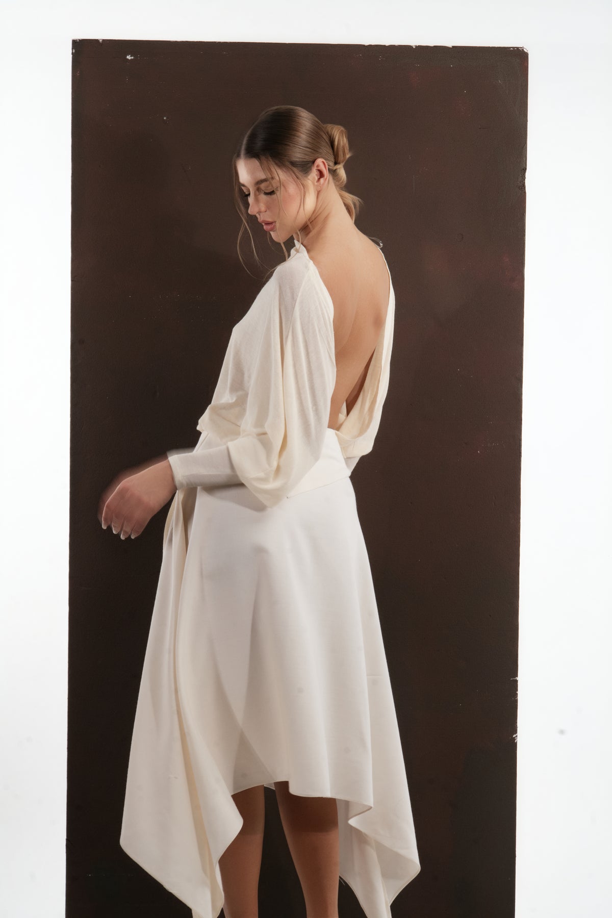 ALISADUDAJ ivory wool open-back drape dress, side view showing draped sleeve and handkerchief skirt
