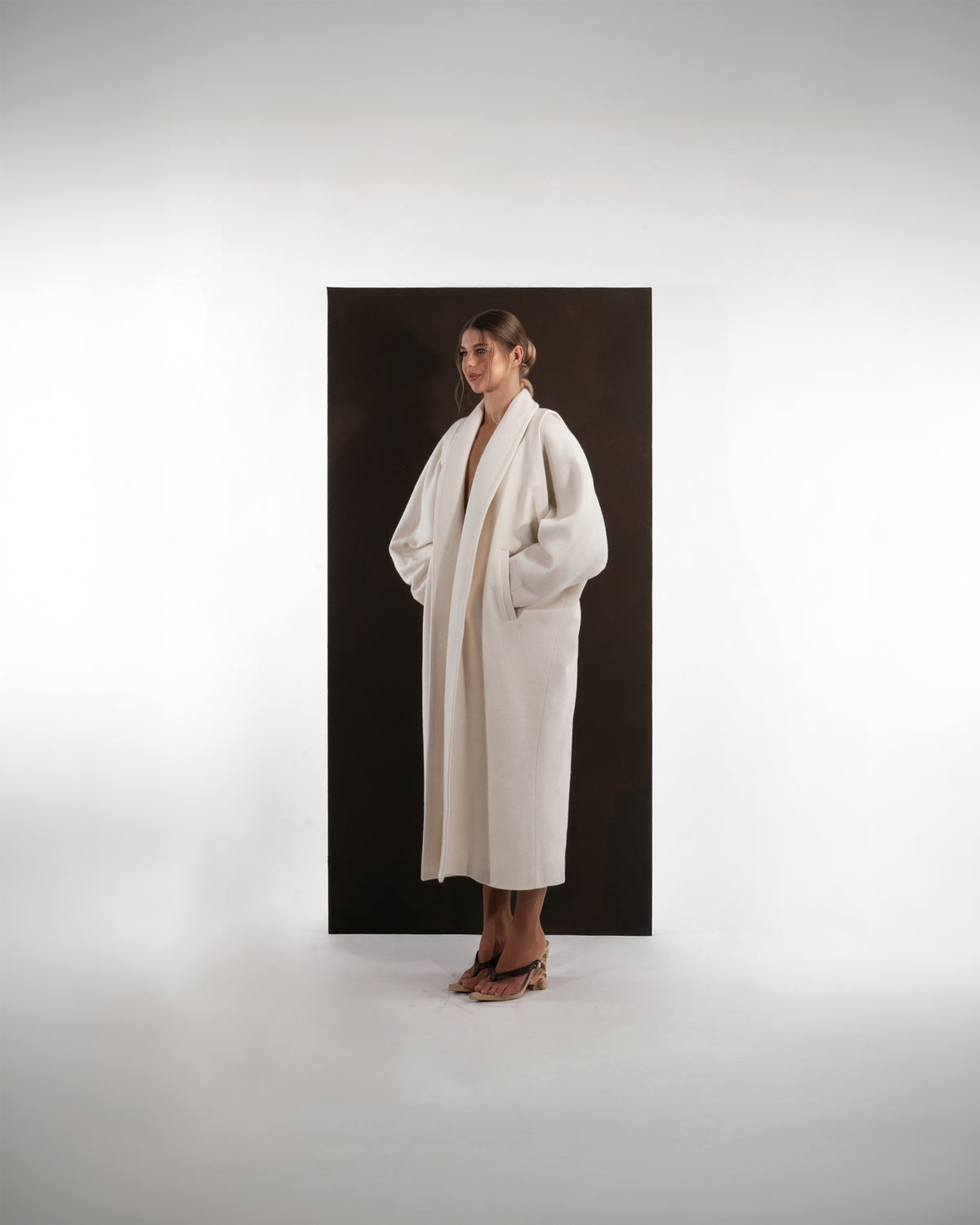 ALISADUDAJ ivory wool cocoon coat, side three-quarter view showing shawl collar and midi length