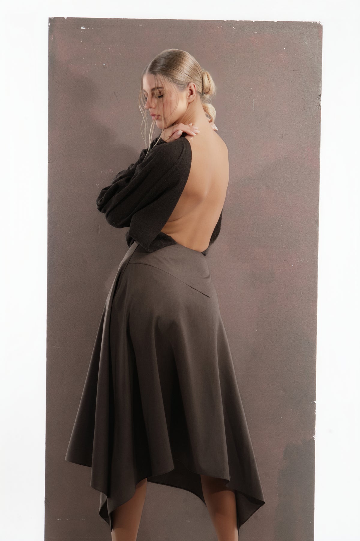 ALISADUDAJ mocha brown wool open-back dress, back three-quarter view showing draped sleeve and pointed hem