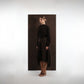 ALISADUDAJ mocha brown wool open-back dress, side profile showing long sleeves and asymmetric skirt