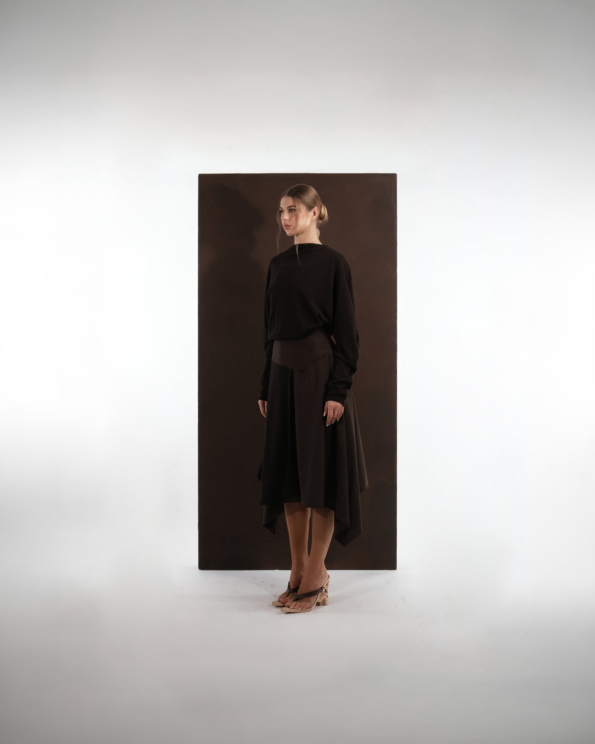 ALISADUDAJ mocha brown wool open-back dress, side profile showing long sleeves and asymmetric skirt