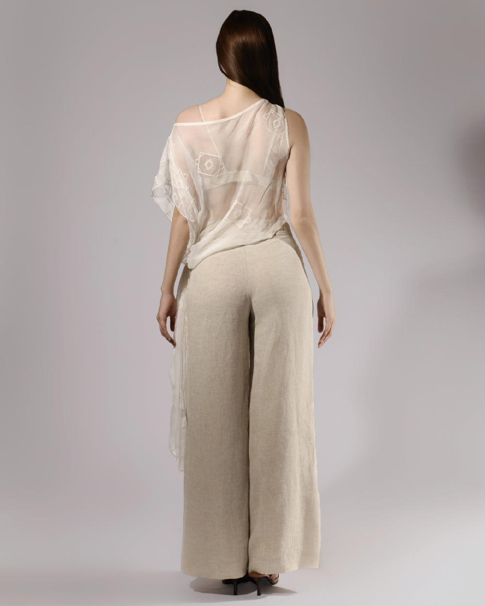 ALISADUDAJ taupe linen set with sheer mesh overlay, back view showing wide-leg trousers and draped overlay