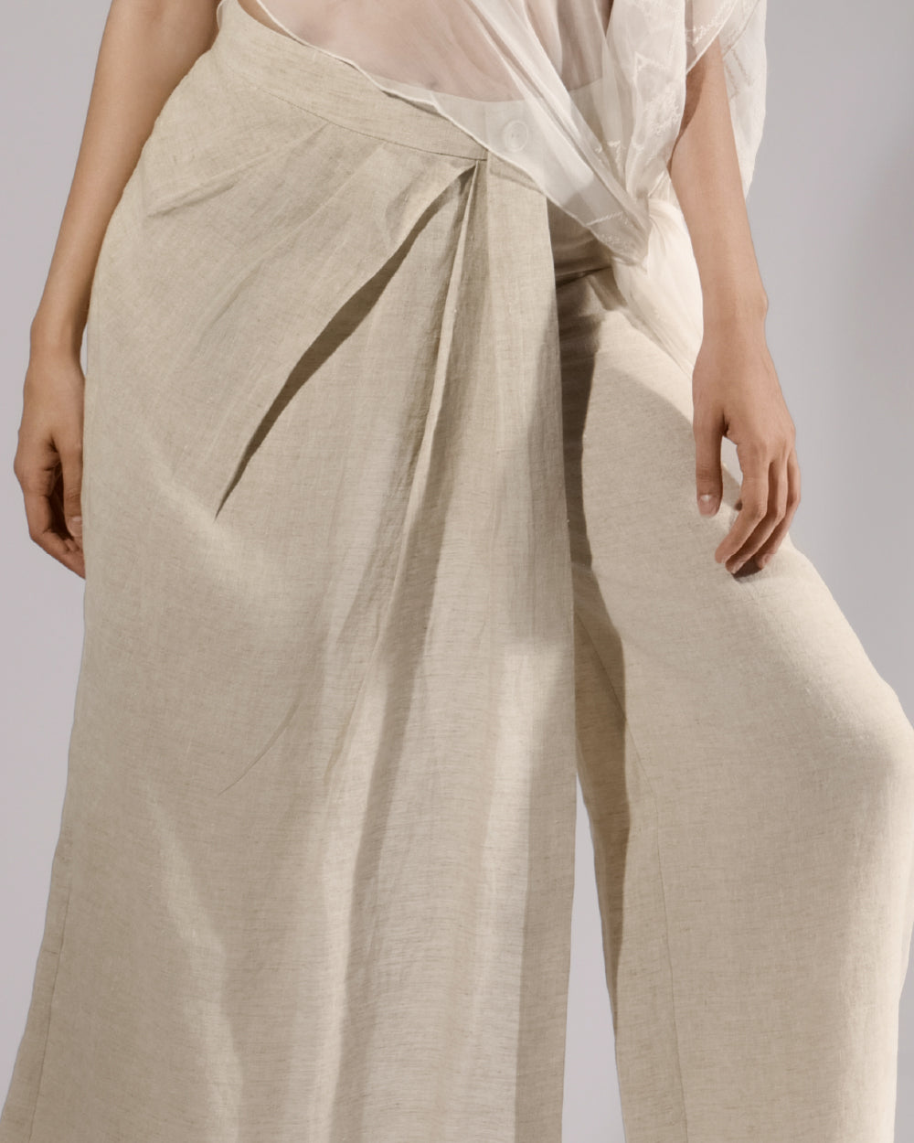 ALISADUDAJ taupe linen wrap trousers, close-up of pleated wrap front and mesh overlay, linen and silk