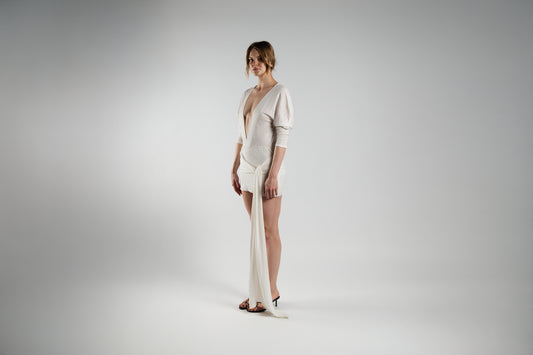 ALISADUDAJ white linen plunge-neck mini dress, front three-quarter view showing draped bodice and sash