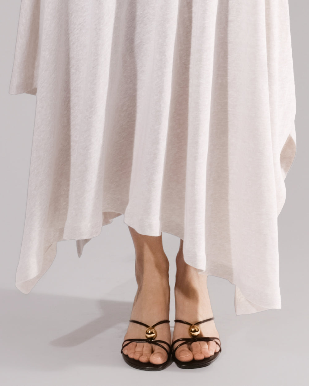 ALISADUDAJ white linen strappy maxi dress, close-up of pointed hem and strappy sandals
